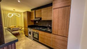 a kitchen with wooden cabinets and a sink and a stove at Luxueux Wave Swing Stay in Taghazout