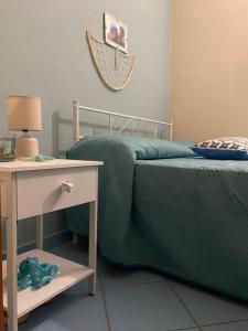 a bedroom with a bed and a nightstand next to a table at Mimí sea house in Pollina