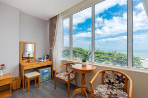 una stanza con tavolo, sedie e ampie finestre di Ngoc Hanh Beach Hotel a Vung Tau