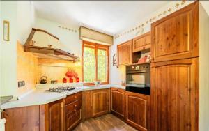 una cucina con mobili in legno e un forno a piano cottura di La casa di Sara a Limone Piemonte