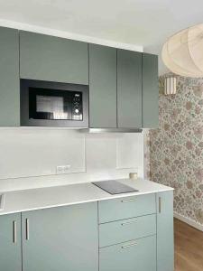 eine Küche mit weißen Schränken und einer Mikrowelle in der Unterkunft M033 superbe studio centre ville in Annemasse