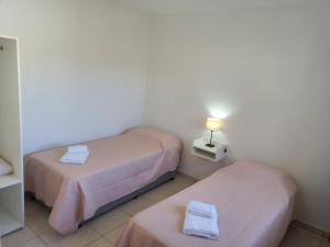 a small room with two beds and a lamp at Departamentos Capernaum in Santa Rosa