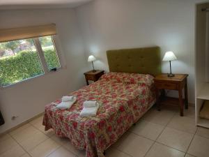 a bedroom with a bed with two towels on it at Departamentos Capernaum in Santa Rosa
