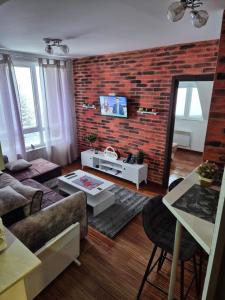 a living room with a brick wall at Castello apartman Kopaonik Kraljevi Cardaci komplex in Kopaonik