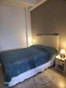 ボンビーニャスにあるResidencial Zimbros 2の青い掛け布団が敷かれたベッドのある寝室