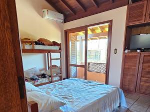 En eller flere senge i et værelse på Casa espaçosa e acolhedora em Garopaba