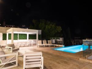a patio with chairs and a pool at night at Villa Gaia - Sunset Views, Indoor Heated Pool, Sauna and Games Room in Mellieħa