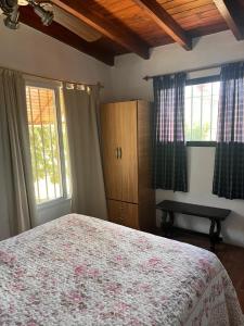 a bedroom with a bed and two windows at Cabaña Abuela Ana in La Falda +3 photos