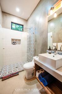 a bathroom with a sink and a toilet and a shower at Steps to the Main Surf Break - 3 Bedroom House in Refundores