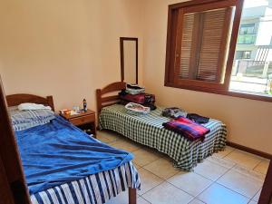 En eller flere senge i et værelse på Casa espaçosa e acolhedora em Garopaba