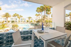 a patio with a table and chairs and a pool at Oasis Lanz Beach Mate in Costa Teguise
