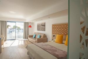 a bedroom with a bed and a couch in a room at Oasis Lanz Beach Mate in Costa Teguise