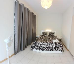 sypialnia z łóżkiem z czarno-białą pościelą w obiekcie Flat Mindelo Deluxe 30 w mieście Mindelo