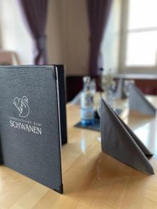 a book sitting on top of a table with a laptop at Landgasthof Zum Schwanen in Durach
