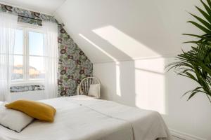 a white bedroom with a bed and a window at Villa Bro in Brastad