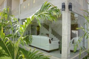 a white couch sitting on the side of a building at Hotel Tobiko in Trincomalee