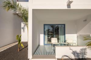 a white house with a black and white tile floor at Oasis Lanz Beach Mate in Costa Teguise