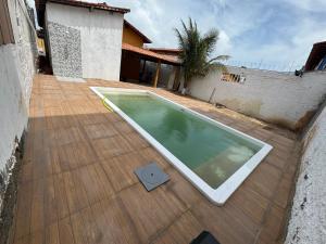 a swimming pool on a wooden deck with a house at Salinas Atalaia in Salinópolis