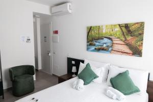 a bedroom with a white bed with a painting on the wall at B&B I LAKE IT BELLAGIO in Bellagio