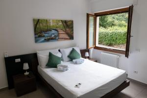 a bedroom with a bed with green pillows and a window at B&B I LAKE IT BELLAGIO in Bellagio
