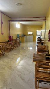 una clase con filas de escritorios de madera en una habitación en Karajas hotel, en Quixeramobim