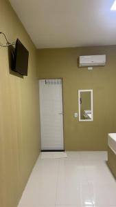 una habitación vacía con puerta y espejo en Karajas hotel, en Quixeramobim