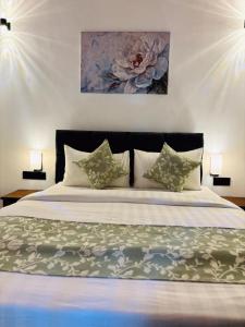 a bedroom with a large bed with two lamps at Chaya Beach Hotel,Tangalle in Tangalle