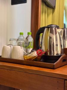 a tray with a tea kettle and cups on a counter at Chaya Beach Hotel,Tangalle in Tangalle