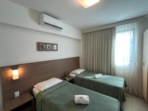 累西腓帆船酒店的一间有两张床和一扇窗户的酒店房间