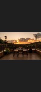 a patio with two tables and a sunset in the background at Recanto sol nascente in Rio Formoso
