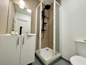 a white bathroom with a shower and a toilet at Les lices, centre ville de Rennes in Rennes