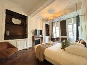 a bedroom with a large bed and a chandelier at Les lices, centre ville de Rennes in Rennes