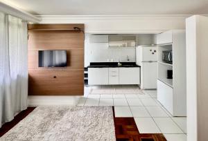 a kitchen with white appliances and wooden cabinets at João Machado Fortes in Florianópolis