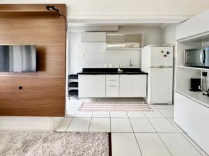 a white kitchen with a refrigerator and a sink at João Machado Fortes in Florianópolis