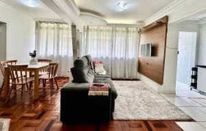 a living room with a green couch and a table at João Machado Fortes in Florianópolis