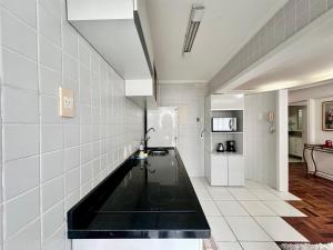 a kitchen with a black counter and a refrigerator at João Machado Fortes in Florianópolis