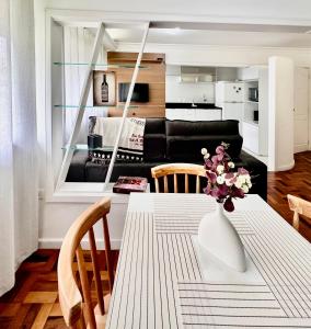 a living room with a table and a black couch at João Machado Fortes in Florianópolis