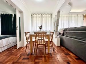a dining room with a table and chairs and a couch at João Machado Fortes in Florianópolis