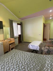 a hotel room with two beds and a desk and a bedroom at At Roubo's in Tsaghkadzor