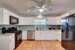 eine Küche mit weißen Schränken und einem Deckenventilator in der Unterkunft bsv_villa721 in Boynton Beach