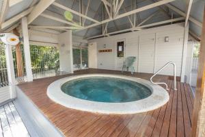 una gran piscina en un porche con terraza de madera en Westwind - Waterfront Retreat, en Goon Nure 16 fotos más