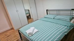 a bed with a towel on it in a bedroom at Baraka Altmore in London