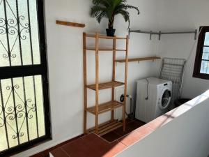 a bathroom with a shelf and a washing machine at Casa Puente ROMANO cerca de Sevilla in Alcalá de Guadaira