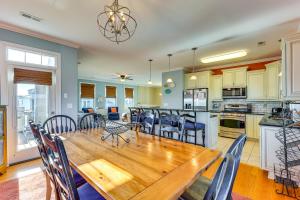 a kitchen and dining room with a wooden table and chairs at Chic Surf City Retreat with Pool Less Than 1 Block to Beach! in Surf City