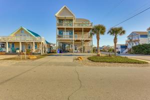 a large house on a street with palm trees at Chic Surf City Retreat with Pool Less Than 1 Block to Beach! in Surf City