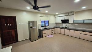 a kitchen with a refrigerator and a ceiling fan at KT Homestay in Jasin