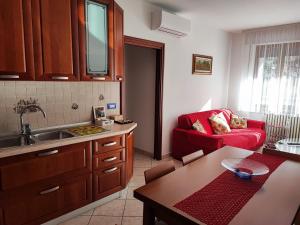 a kitchen with a sink and a red couch at IL GIRASOLE in Tirano