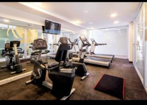 a gym with tread machines and a flat screen tv at Ap 609 Alójate y disfruta la Vista al Río y Atardeceres in Colonia del Sacramento