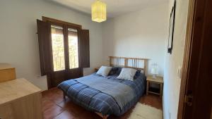 a bedroom with a bed and a window at Acogedora casa en Pampaneira in Pampaneira