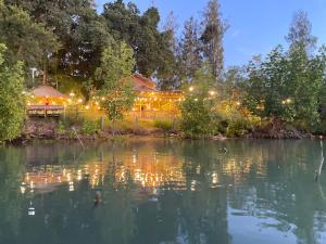 a house with lights on the water at night at Grace House Prachuap in Ko Rom